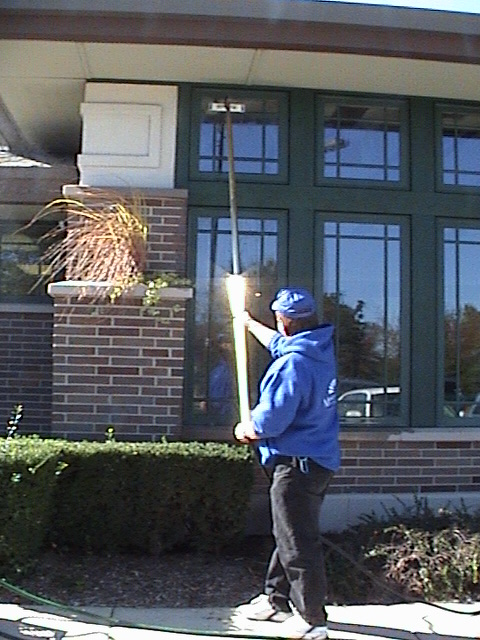 Clean Avenue worker using a water-fed pole on exterior windows