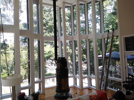 A bright room with a wall of tall windows serviced by Clean Avenue